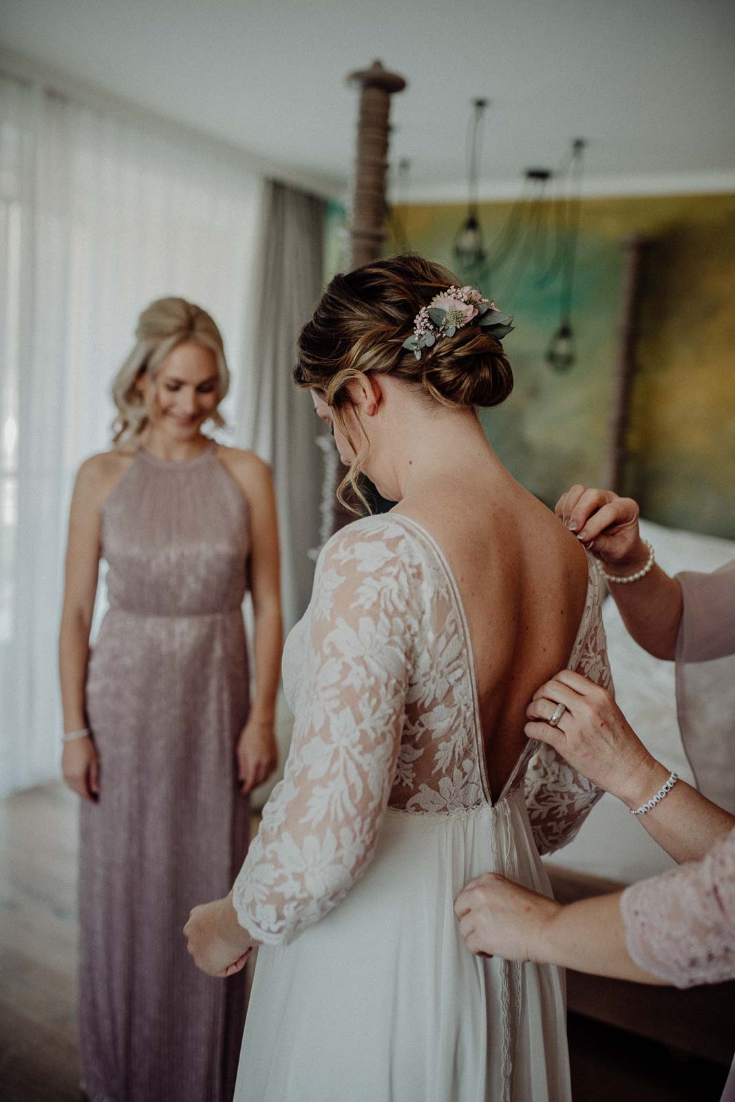 Mama hilft Braut ins Hochzeitskleid