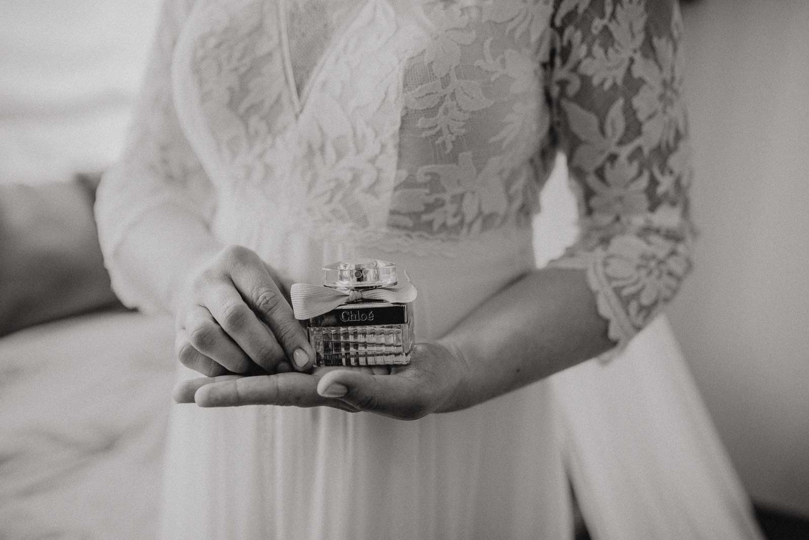 Die Braut zeigt das Parfum welches Sie am Hochzeitstag trägt